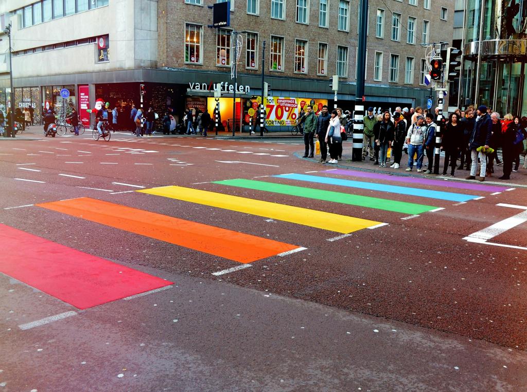 Mensen wachten bij een regenboogstoplicht 